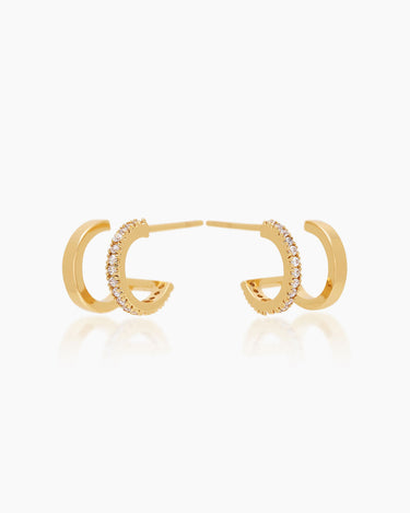The Emilia Huggies, gold double-stacked illusion earrings featuring one hoop paved with cubic zirconia