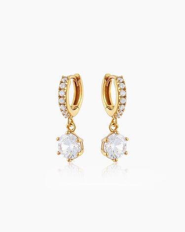The Julia Huggies, gold drop earrings featuring a shining crystal suspended from dainty pavé-set huggies