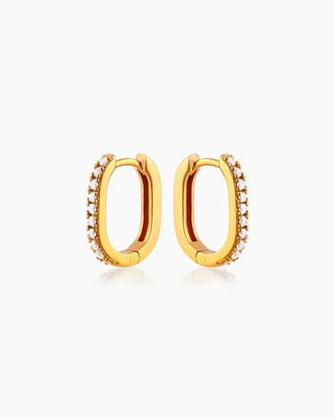 The Lucy Huggies, dainty gold earrings with a high-shine pavé-set finish and unique silhouette