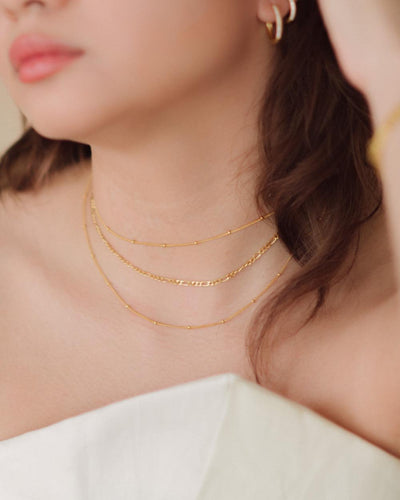 A woman wearing the Louisa Choker and Louisa Necklace layered with a Figaro Choker
