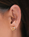 The Anya Huggies, gold illusion earrings that give you three petite hoops and styles in one, worn on a left ear