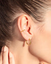 A close up of a woman's ear wearing the Mara Cuffs and the Twilly Hoops