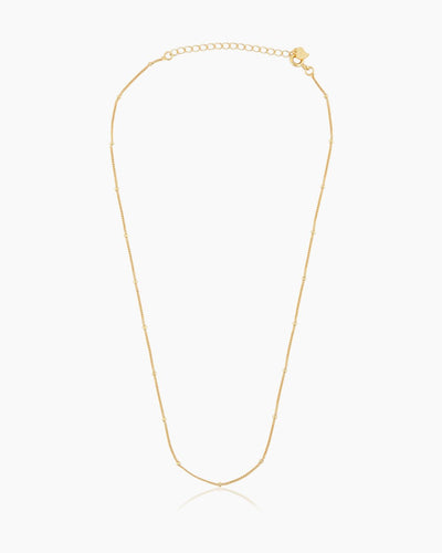 A full-length shot of the Louisa Necklace, a classic gold beaded chain that offers an ultra-stackable minimalist style