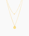The Sofia, a gold two-layer illusion necklace with a dainty golden ball and a classic round pendant