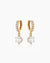 The Julia Huggies, gold drop earrings featuring a shining crystal suspended from dainty pavé-set huggies
