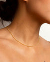 A close up shot of the Louise Necklace worn around a woman's neck