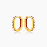 The Lucy Huggies, dainty gold earrings with a high-shine pavé-set finish and unique silhouette