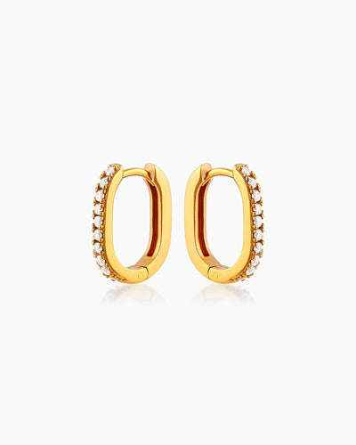 The Lucy Huggies, dainty gold earrings with a high-shine pavé-set finish and unique silhouette
