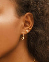 A close up shot of the Sky Huggies, Lia Studs, and Amy Cuffs worn on a woman's ear