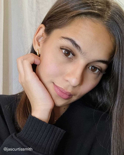 Jasmine Curtis-Smith wearing the Venus Huggies, an oval-shaped gold earring from Penny Pairs